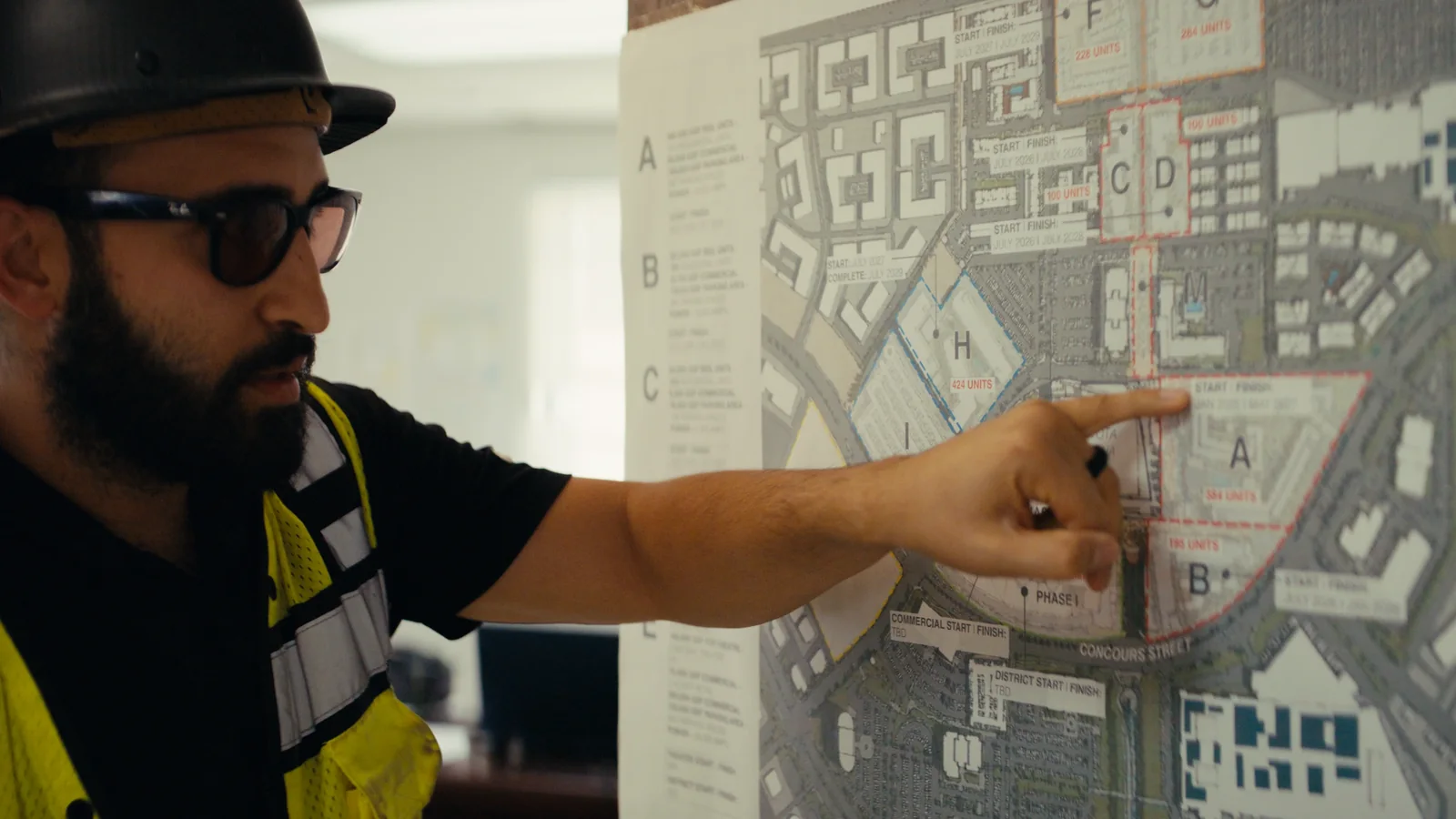 On site, a member of the team pointing at the district lot plan